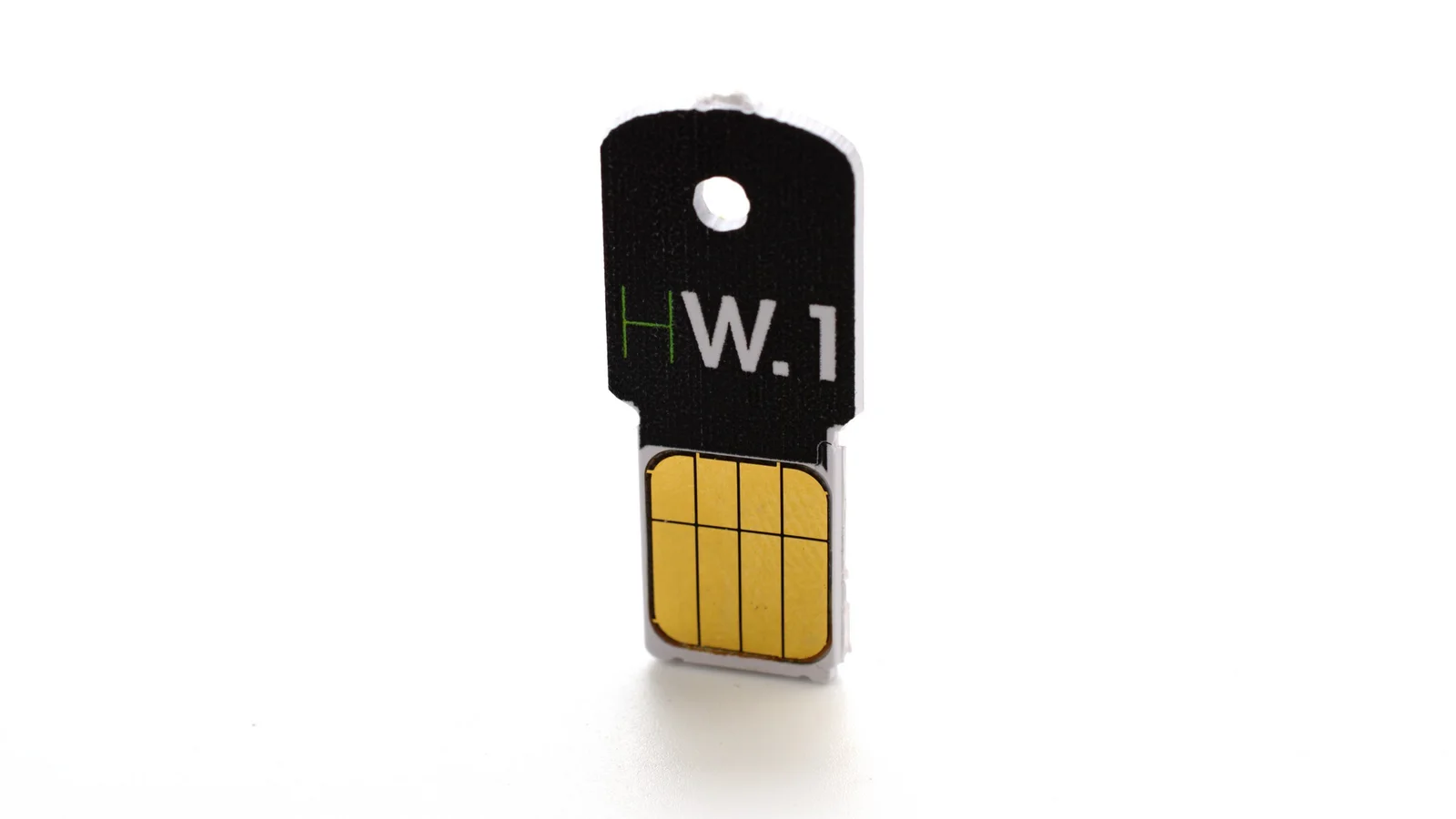 Ledger HW.1, frühes Hardware-Wallet von Ledger im Format eines kleinen USB-Schlüssels mit goldenem Kontaktchip, vor weißem Hintergrund
